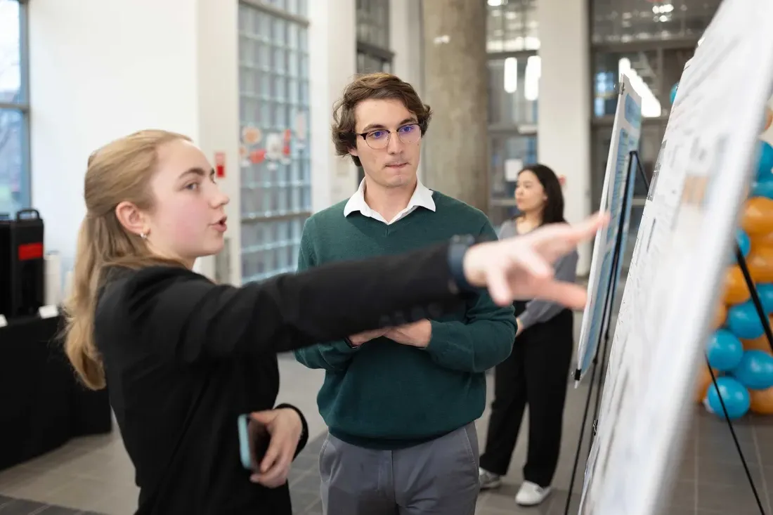 Two students looking at a presentation on a board.